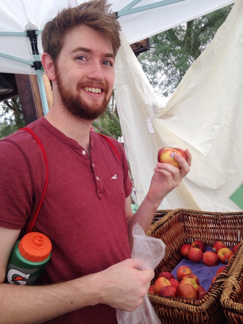 Brayden holding an apple at the market